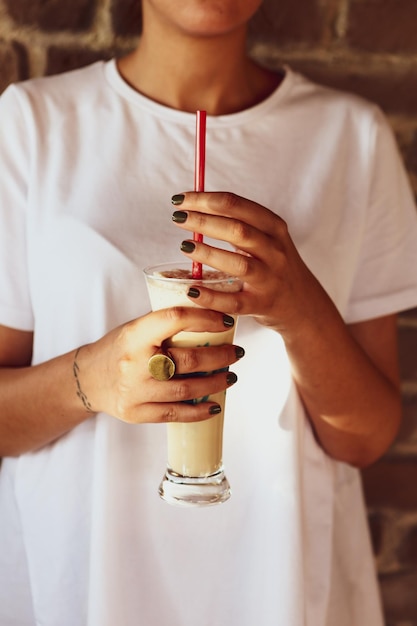 Iced coffee with milk Iced coffee latte Woman holding glass cup of iced coffee