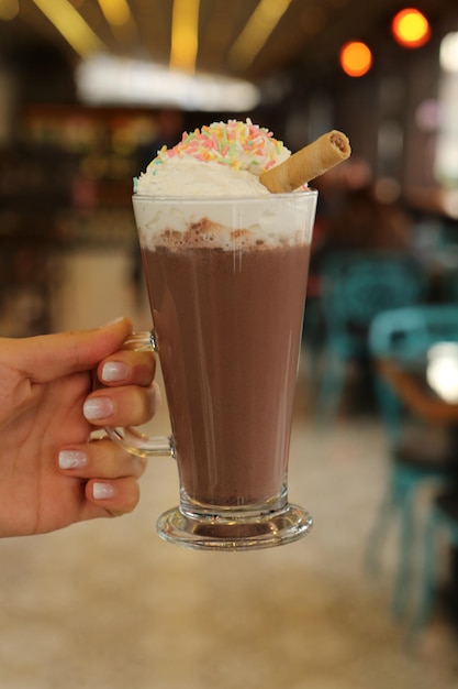 Iced coffee with milk. Iced coffee latte . Woman holding glass cup of iced coffee.