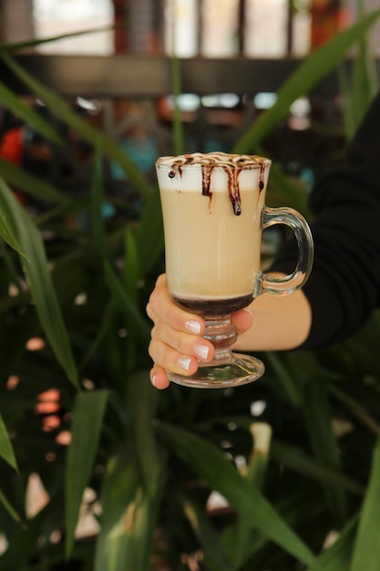 Iced coffee with milk. Iced coffee latte . Woman holding glass cup of iced coffee.