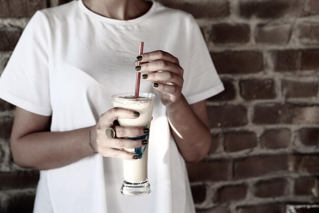 Iced coffee with milk. Iced coffee latte . Woman holding glass cup of iced coffee.