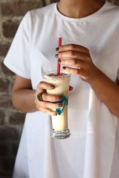 Iced coffee with milk Iced coffee latte  Woman holding glass cup of iced coffee