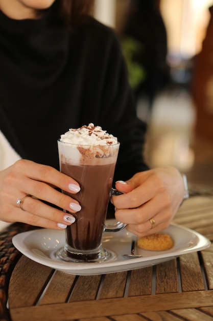 Iced coffee with milk. Iced coffee latte . Woman holding glass cup of iced coffee.