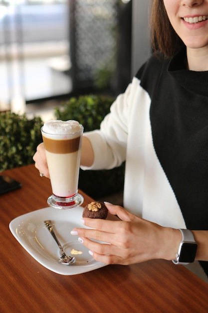 Iced coffee with milk. Iced coffee latte . Woman holding glass cup of iced coffee.