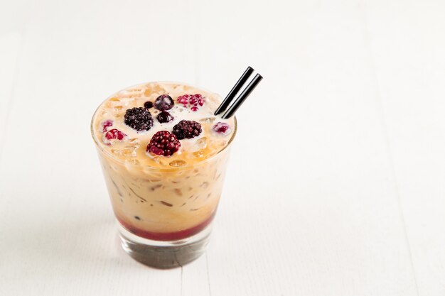 Iced coffee with milk,  syrup and berries. Fresh summer drink.