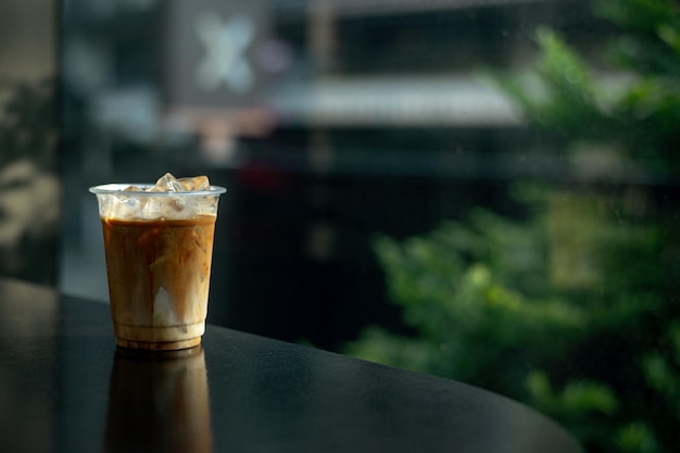 Iced Latte Coffee in a Plastic Glass on a Black Table at a Coffee shop