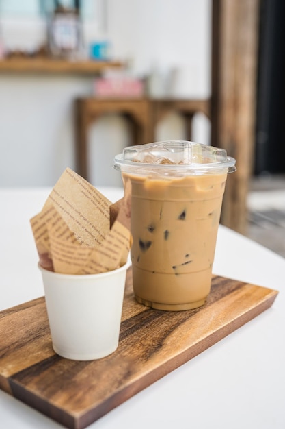 Iced Latte coffee in plastic glass and dessert chocolate ball on wooden tray