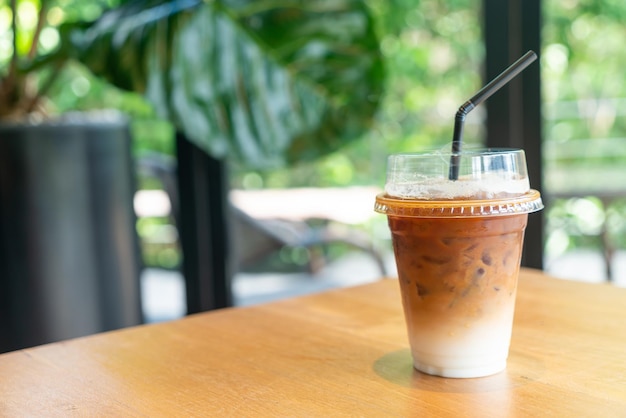 iced latte coffee in takeaway glass on table in coffee shop cafe restaurant