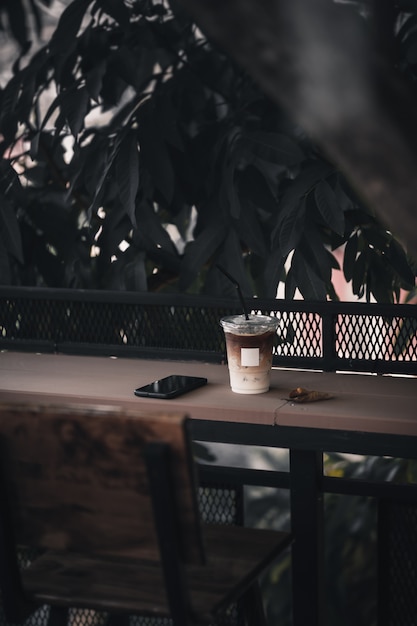 Iced latte and mobile phone on wood bar