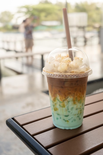 Iced milk green tea mixed milk coffee topping with popcorn showing separate in a layer coffee