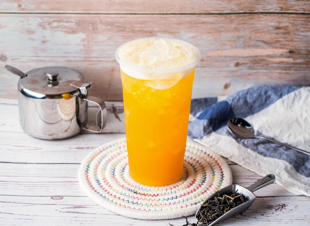 Photo iced passion fruit and aloe vera green tea with sugar pot and spoon served in disposable glass isolated on table side view of hong kong tea