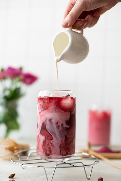 Iced pink matcha with milk in tall glass