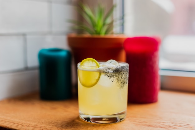 iced sour cocktail in rocks glass with lemon wheel