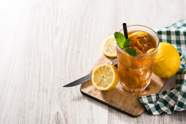 Iced tea drink with lemon in glass and ice