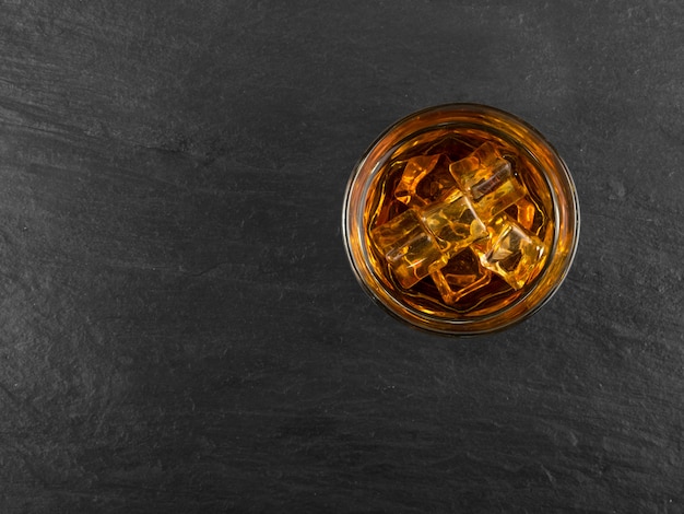 Iced Whiskey Glass on Natural Black Stone Background