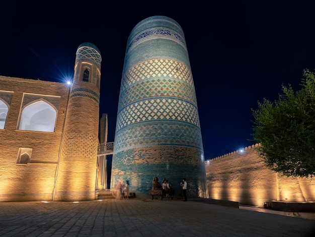 Ichan Kala old city at night with illuminated Kalta Minor minaret ancient madrasah Khiva Uzbekistan