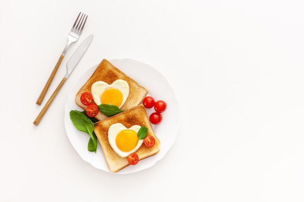 Idea for the celebration of Valentine's day: breakfast - toast with scrambled eggs in the form of hearts