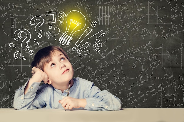 Idea Smart kid student with lightbulb on blackboard