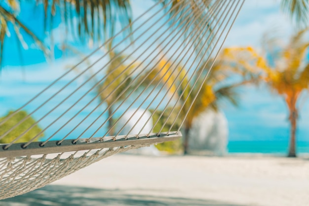 Idyllic beach with coconut trees and hammock, tranquil relaxing summer vibes. Recreational closeup