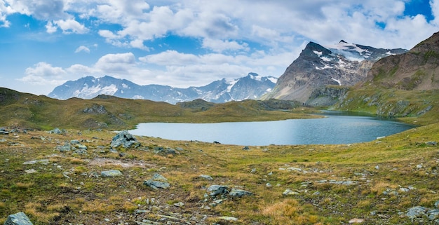 Idyllic blue alpine lake high up on the mountains, scenic landscape rocky terrain at high altitude on the Alps, panoramic view