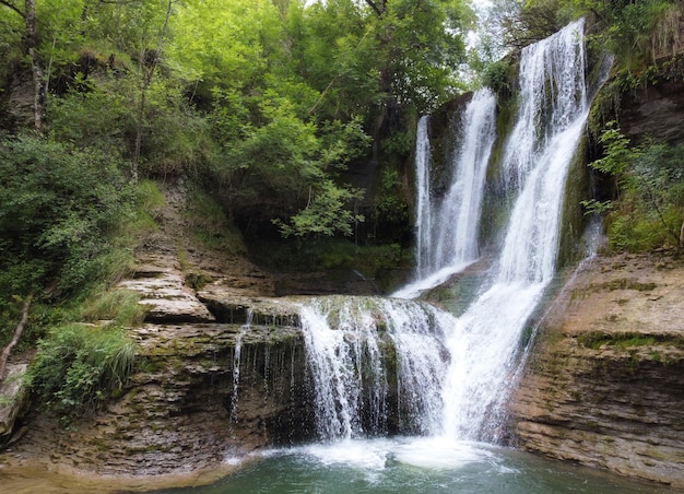 Idyllic rain forest waterfall, stream flowing in the lush green forest.