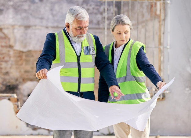 If your dreams dont scare you, they are too small. Shot of two  engineers looking at blueprints while standing on a construction site.