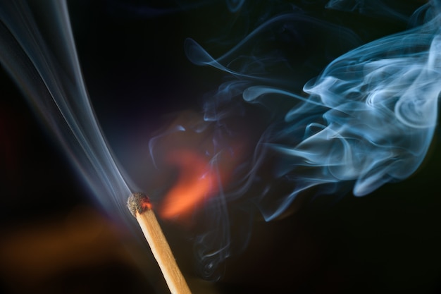 Ignition of match with smoke, isolated on black background