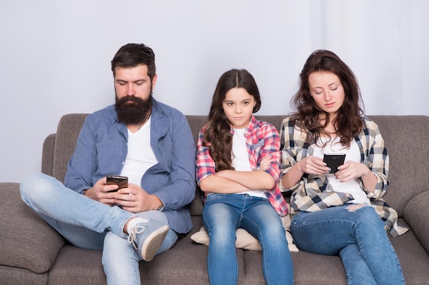 Ignored child Busy parents surfing internet smartphones Dad and mom ignoring daughter needs Bad habits Parenthood failure Ignored baby Offended feelings Stop ignoring kid Stuck in online