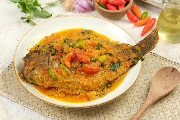 Photo ikan pesmol tilapia or ikan nila or pesmol fish with yellow curry