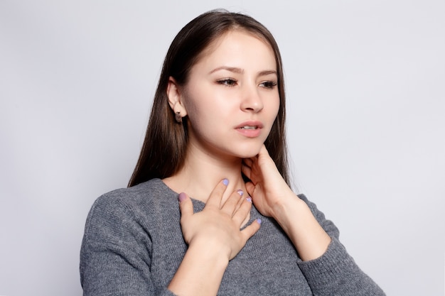 Illness, Health Care, people, Medicine concept - Throat Pain. Closeup Of Sick Woman With Sore Throat Feeling Bad, Suffering From Painful Swallowing. Beautiful Girl Touching Neck With Hand