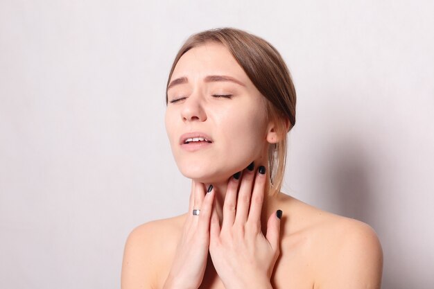 Illness, Health Care, people, Medicine concept - Throat Pain. Closeup Of Sick Woman With Sore Throat Feeling Bad, Suffering From Painful Swallowing. Beautiful Girl Touching Neck With Hand