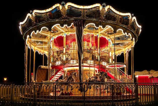 Illuminated classical carousel at night on a street of Gdansk city