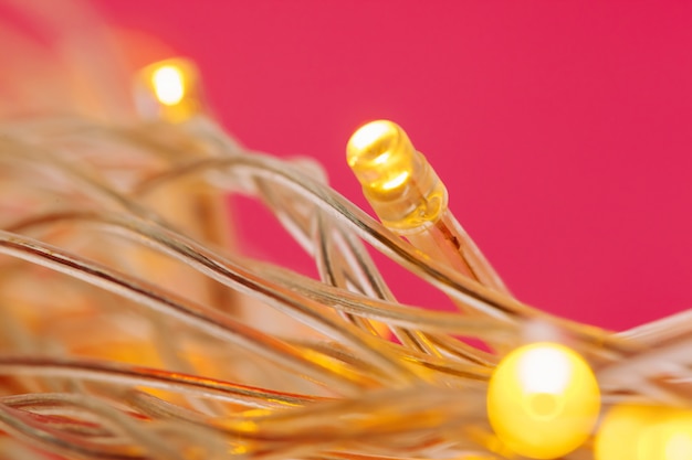 Illuminated garland lights on bright pink 