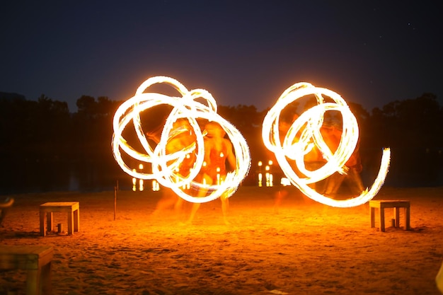 Photo illuminated lighting equipment on beach against sky at night