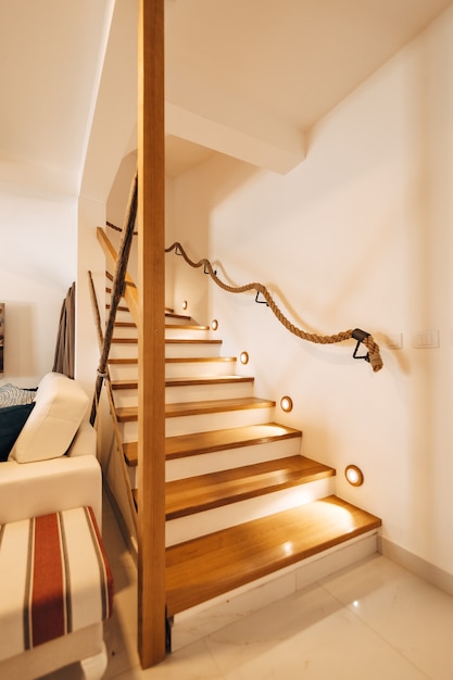 Illuminated staircase on steps and railings in a house with white walls