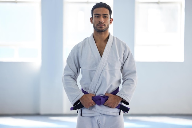 Im almost at the top Cropped portrait of a handsome young male martial artist standing with his hands on his belt in the gym