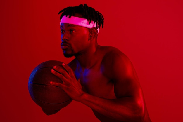 Im a beast out on the court Red filtered shot of a young sportsman posing with a basketball in the studio