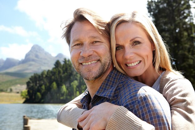 Im holding on to this one Portrait of an affectionate mature couple sitting on a pier out on a lake