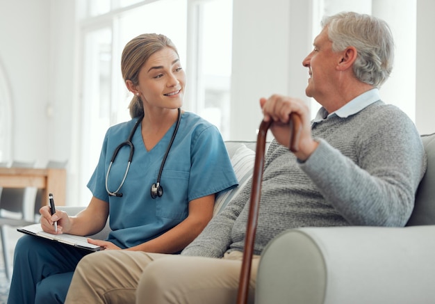 Im impressed with the work youve put in Shot of a young doctor running through a checklist with her patient during a checkup at home