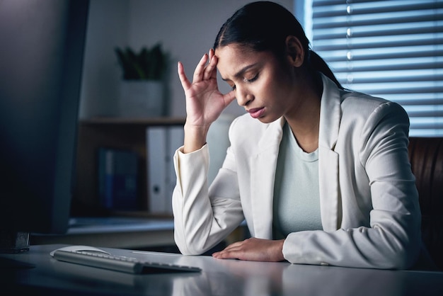 Im in for a long night Shot of an attractive young businesswoman sitting alone in the office at night and feeling stressed