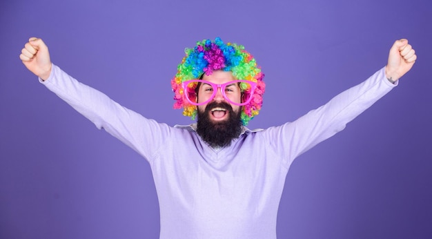 Im a winner Bearded man celebrating victory in clown wig hairstyle Man in fashion wig with happy winning gesture Hipster man wearing rainbow wig hair Happy man with long beard and curl wig