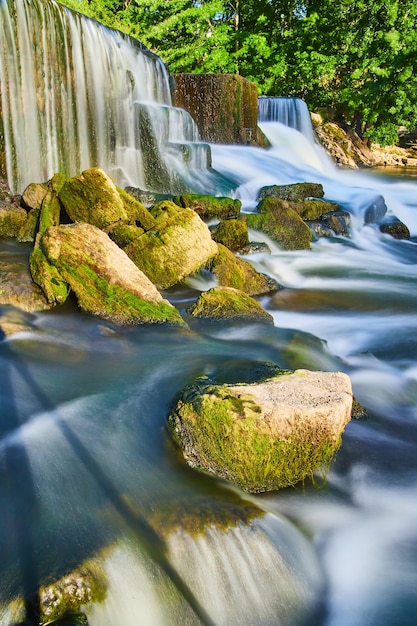 Image of Algae rocks next to manmade waterfalls and smooth water