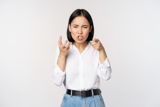 Image of angry pissed off woman shaking from anger clench hands and grimacing furious annoyed and outrated standing over white background