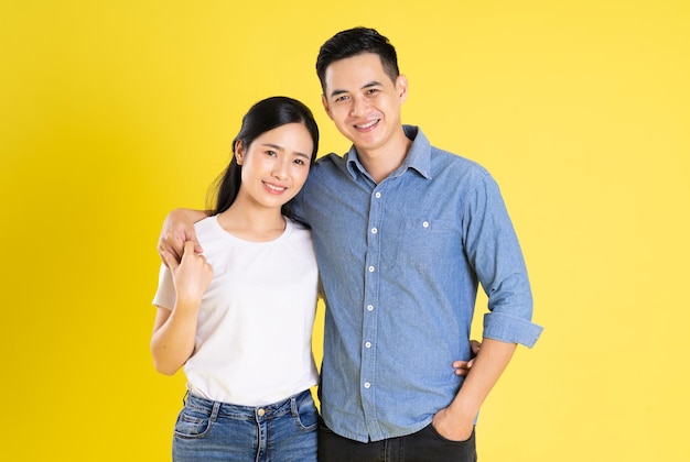 Image of asian couple posing on yellow background