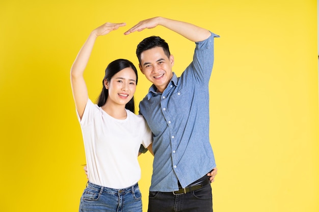 Image of asian couple posing on yellow background