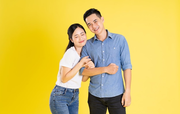 Image of asian couple posing on yellow background