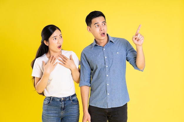 Image of asian couple posing on yellow background