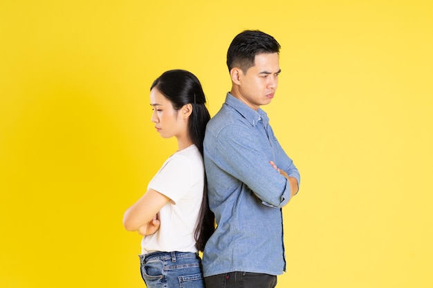 Image of asian couple posing on yellow background