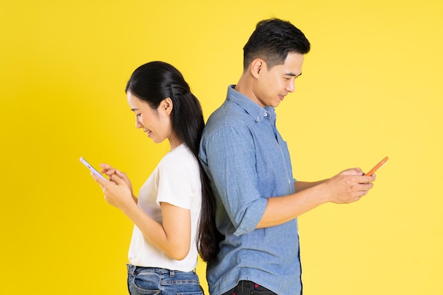 Image of asian couple posing on yellow background