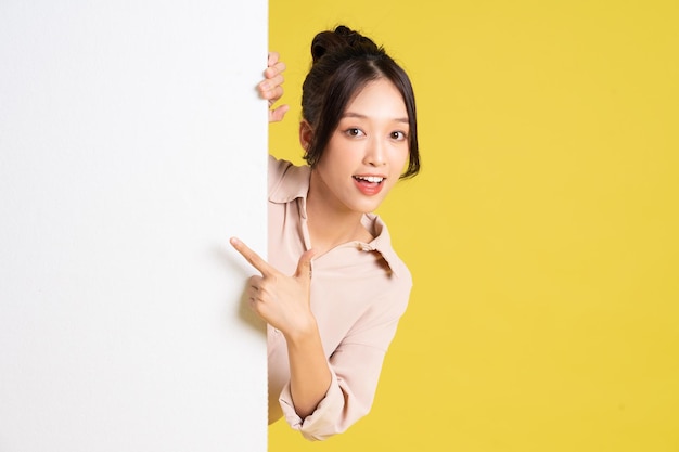 Image of asian girl standing and posing with billboard