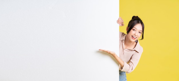 Image of asian girl standing and posing with billboard